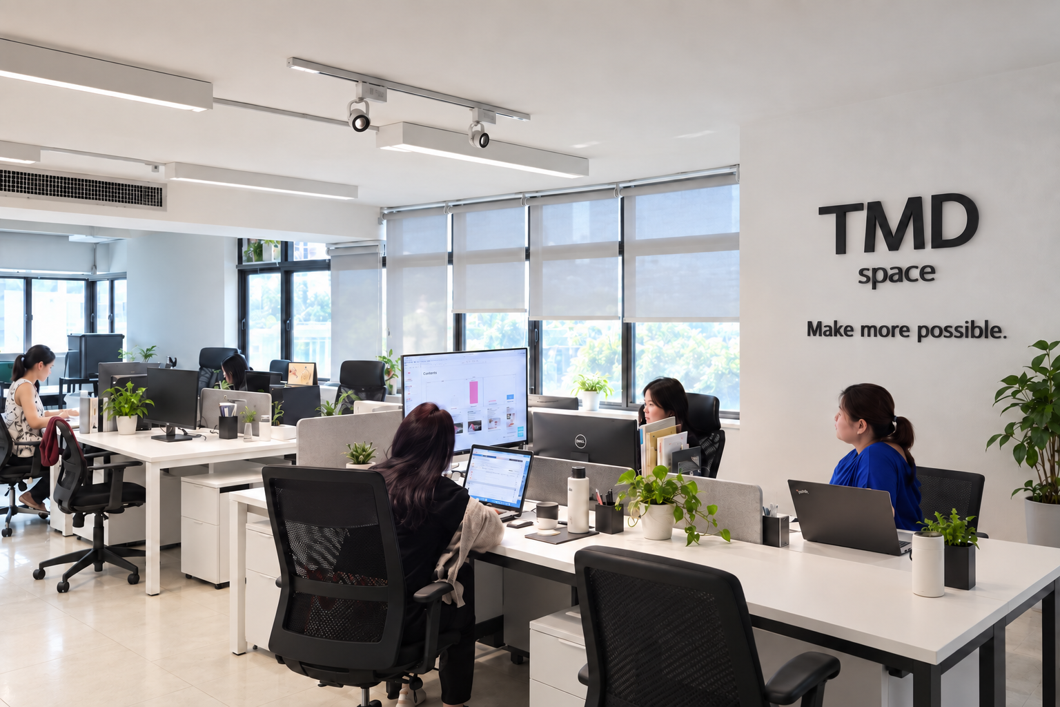 Modernized TMD SPACE office concept with white desks, daylight and updated wall branding